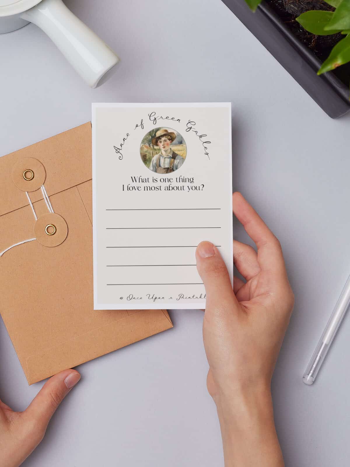 Gilbert Blythe friendship note being held by a woman's hand next to a manila envelope.