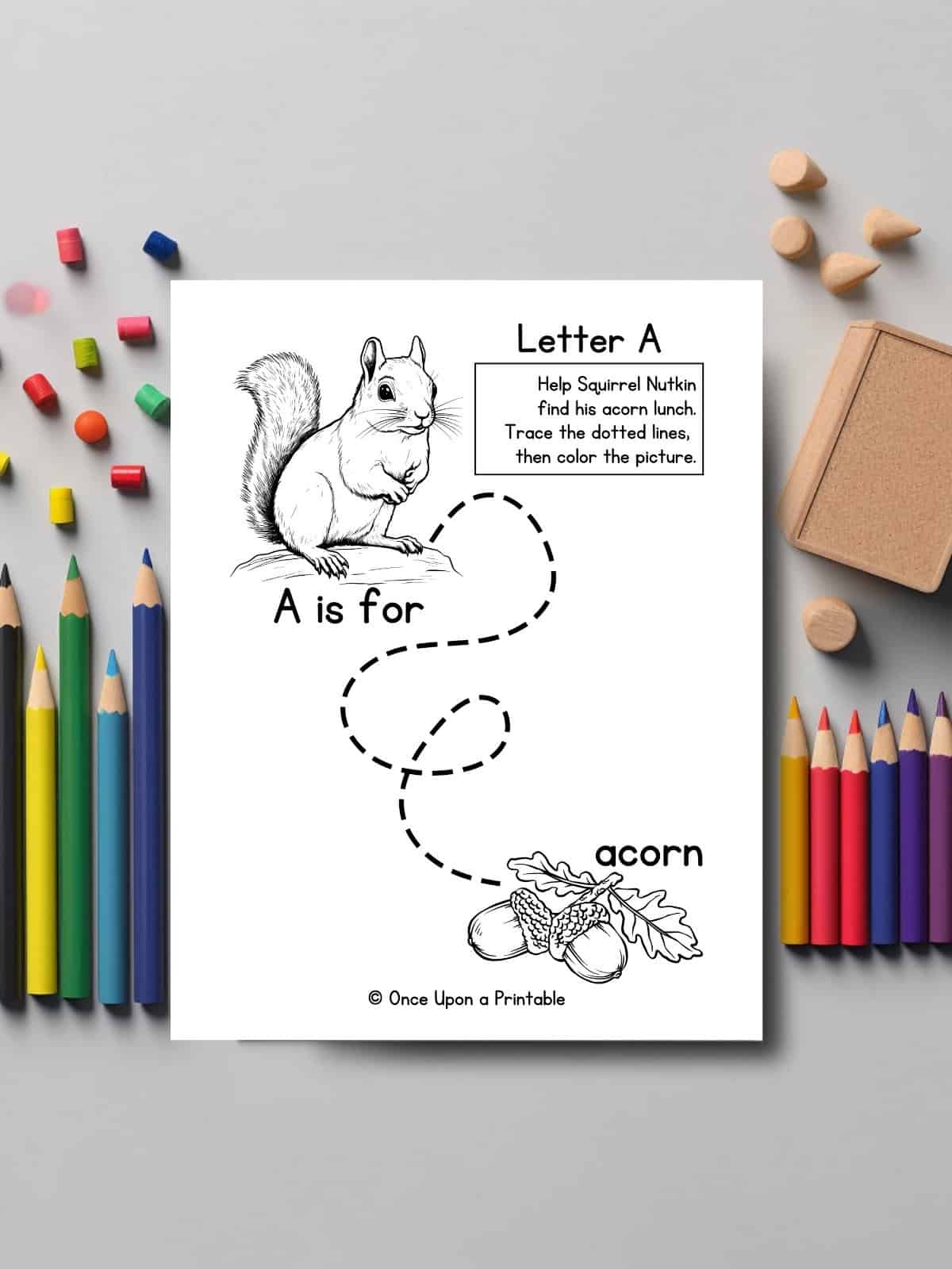 Line tracing practice for Letter A laying on a table with colored pencils.