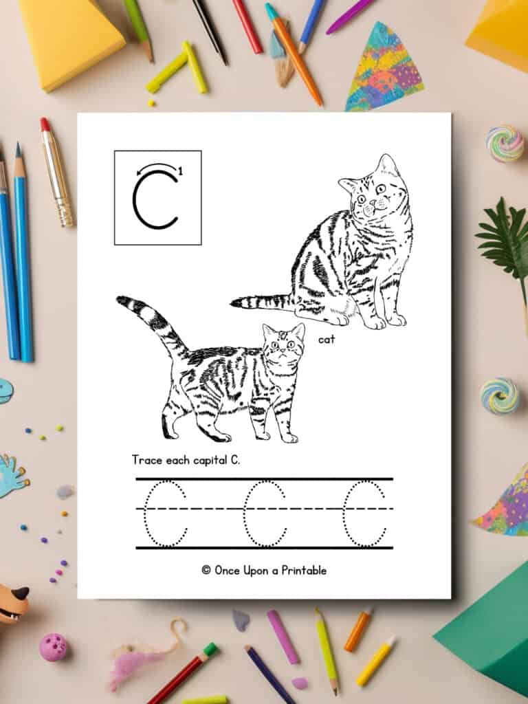 Letter C capital tracing coloring page with black and white graphics of cats laying on a table with coloring pencils. 
