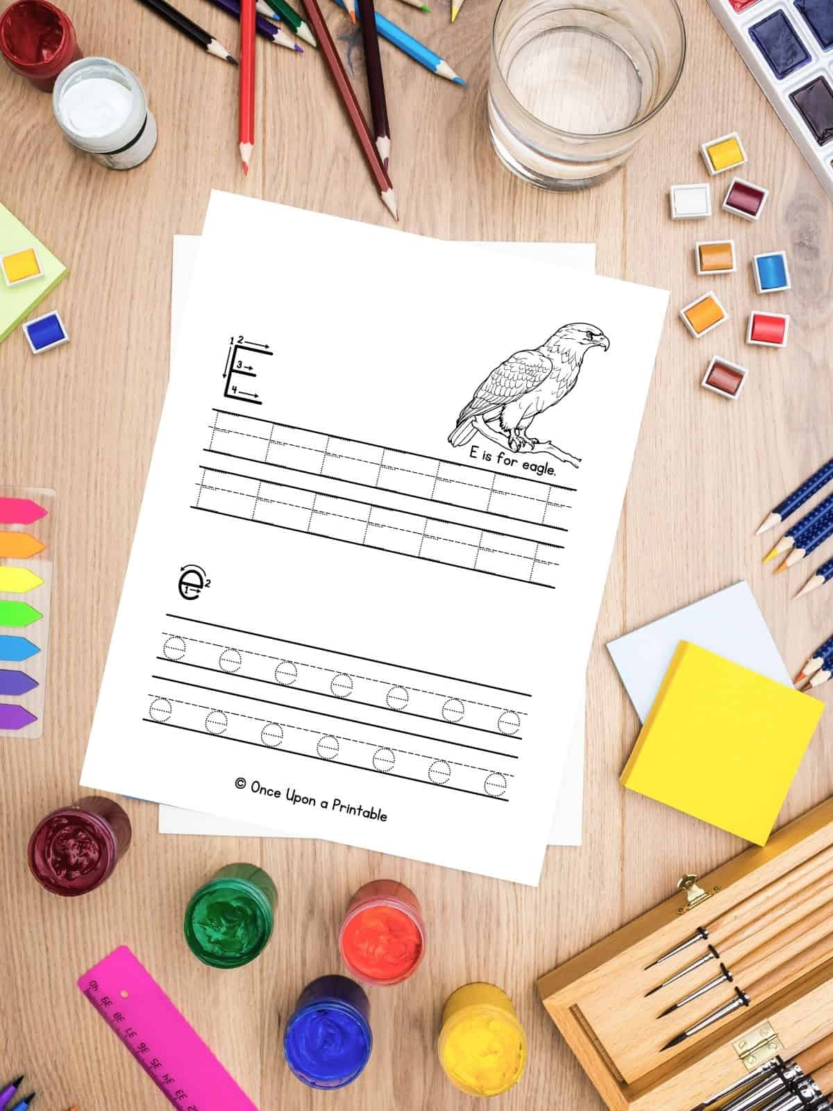 Letter E is for Eagle worksheets laying on the table with art supplies. 