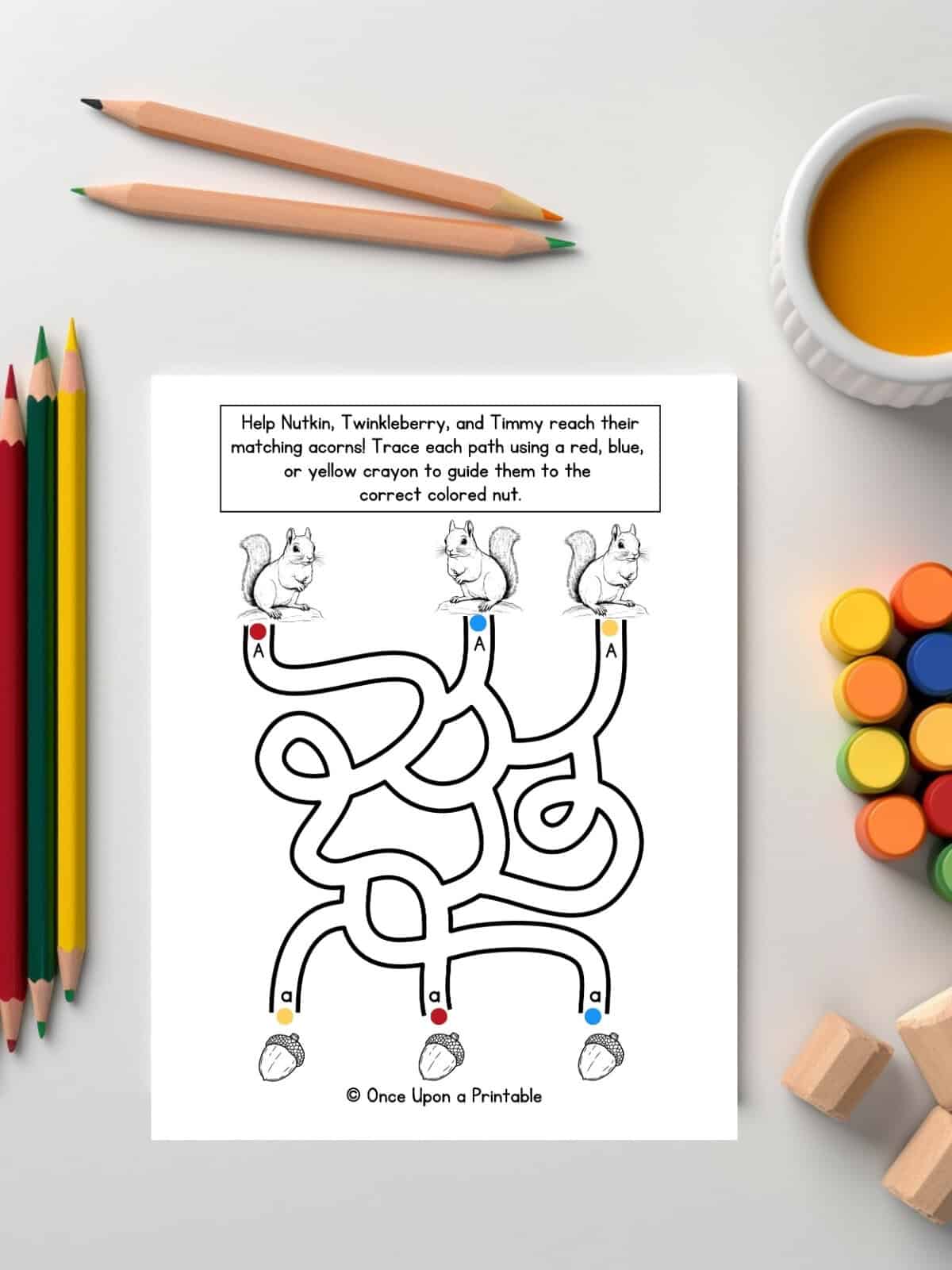 Squirrel and acorn maze fun letter A unit study worksheet laying on a white table with coloring pencils.