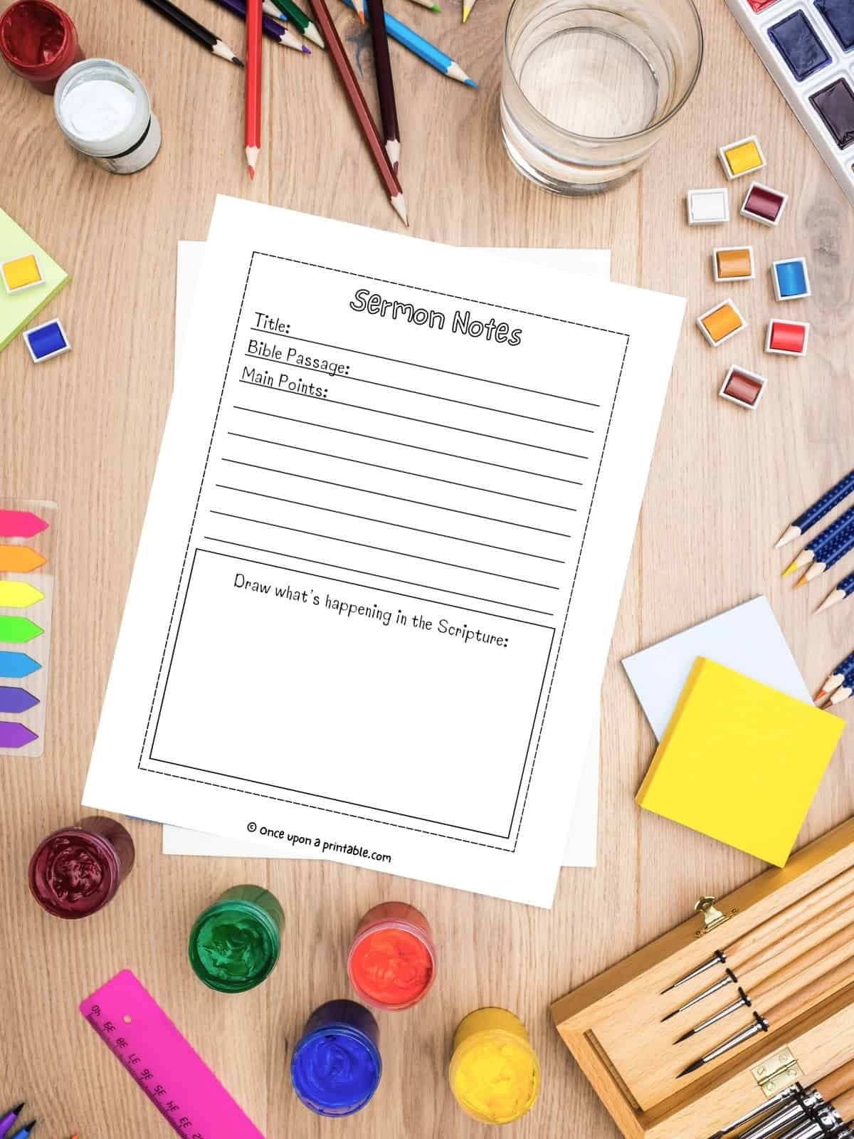 The simplest sermon notes for kids format laying next to all kinds of art supplies.