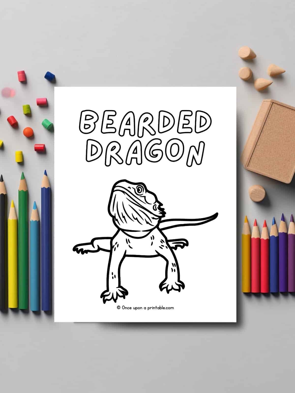 B is for Bearded Dragon coloring page laying on a grey table with pencils.