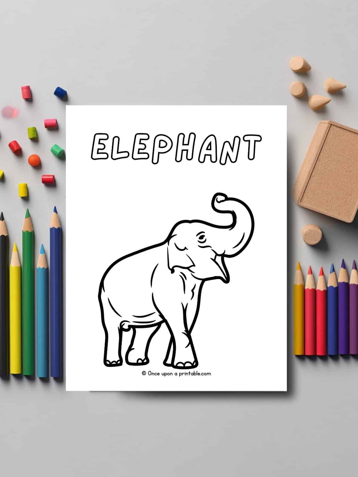 E is for Elephant animal coloring page laying on a table with coloring pencils. 