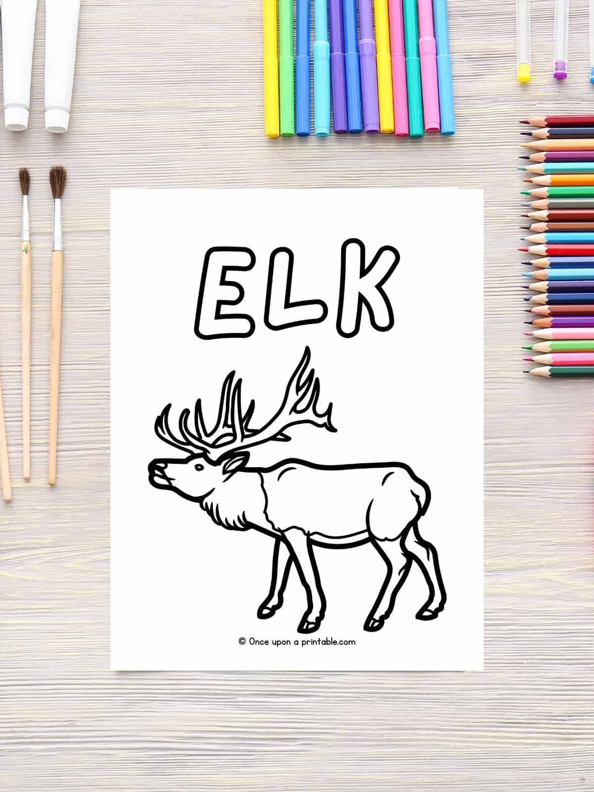 E is for Elk animal coloring page laying on a table with paint brushes and coloring pencils. 