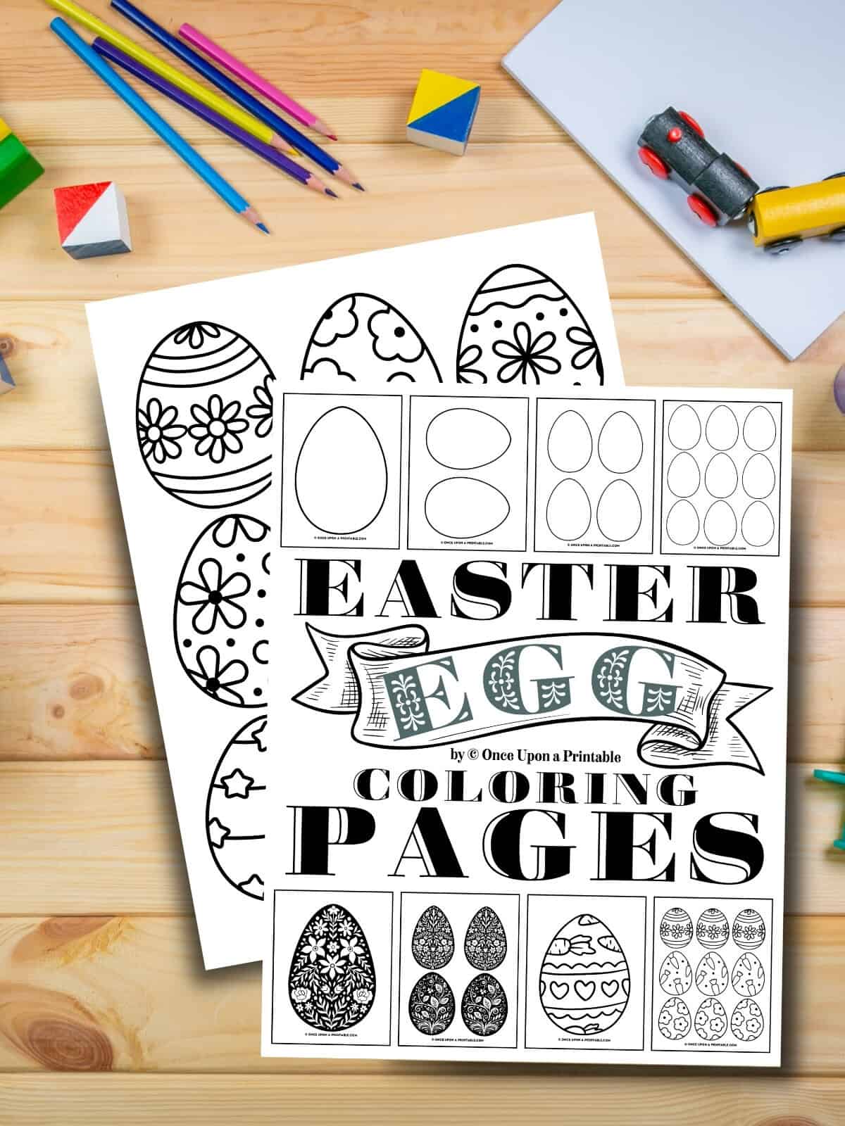 Easter egg coloring pages and templates laying on a wooden table with coloring pencils.