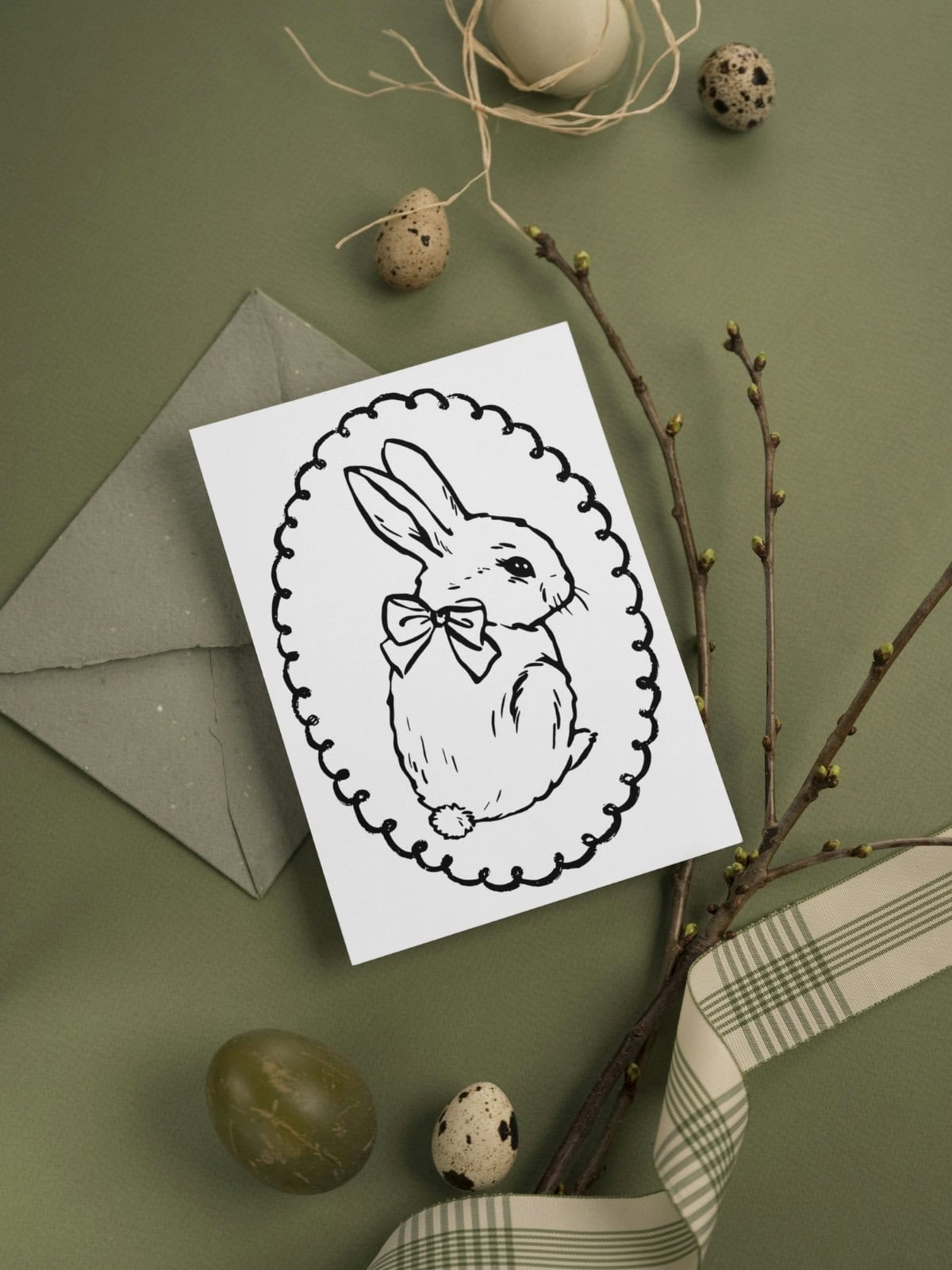 Easter bunny coloring card with adorable bunny rabbit laying on a green background.