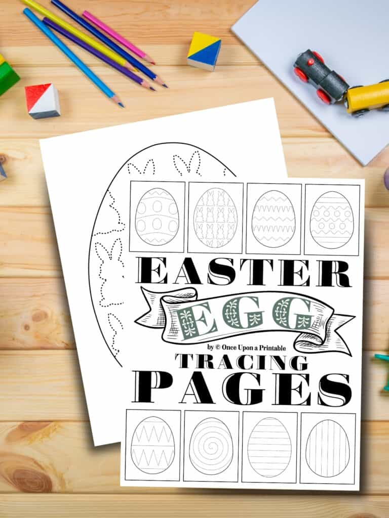 Easter egg tracing worksheets for kids laying on a wooden table with coloring pencils and toys.