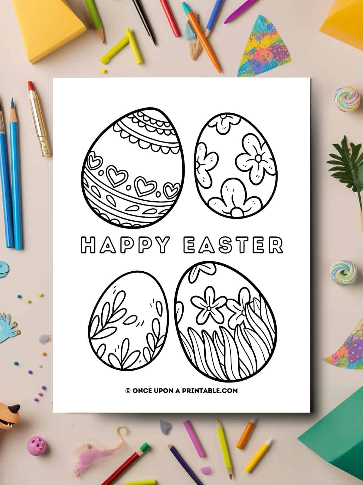 Happy Easter kids coloring easter eggs page laying on a table with coloring supplies.