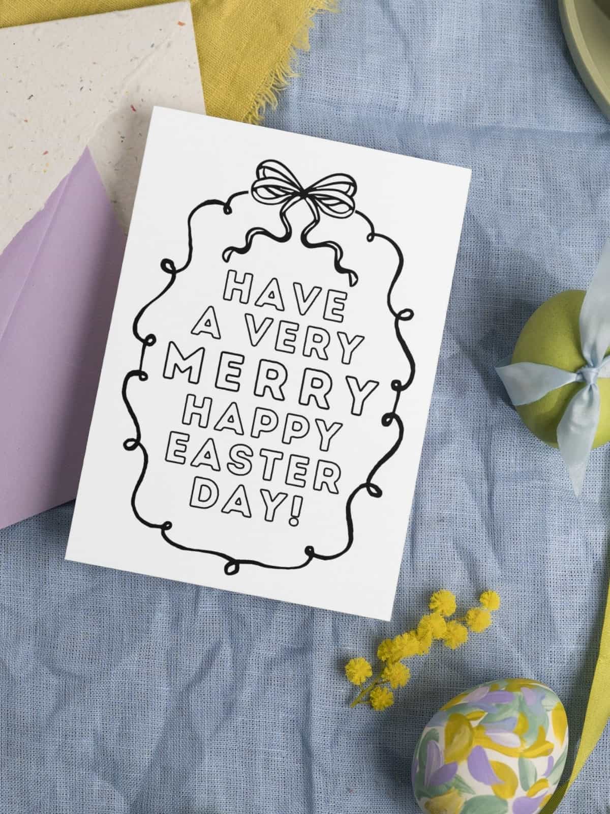 Have a very merry happy easter day coloring card laying on a pastel fabric background.