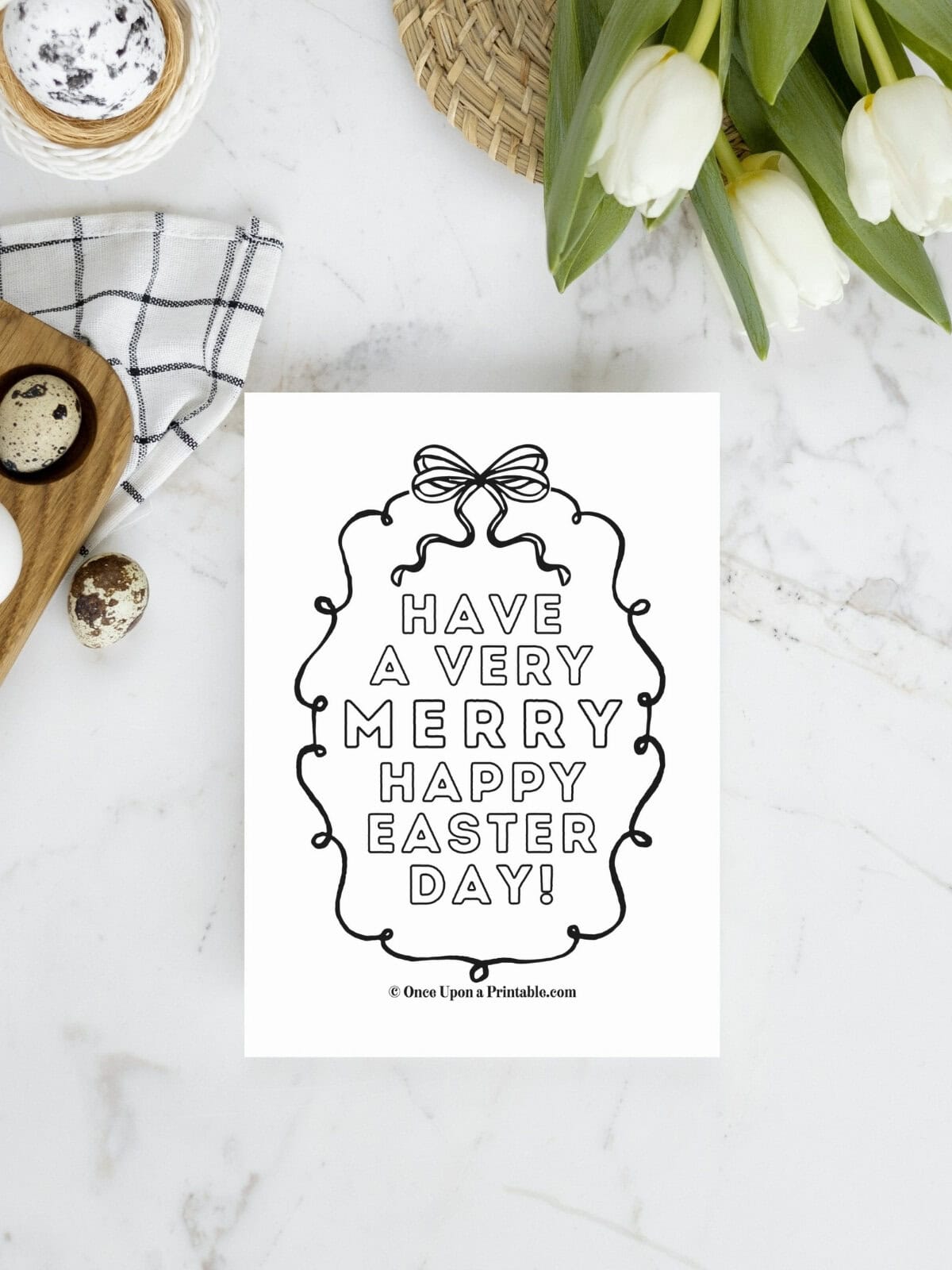 Have a very merry happy easter day coloring page laying on a marble tabletop with tulips and eggs.