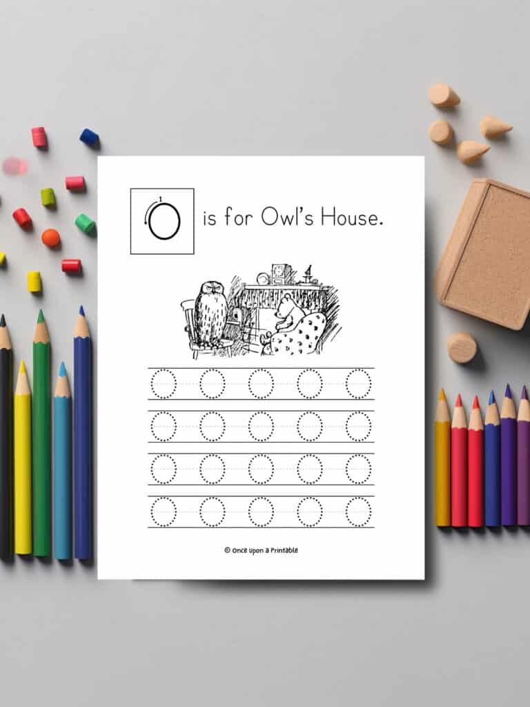 O is for Owl letter tracing worksheet laying on a table with coloring pencils.