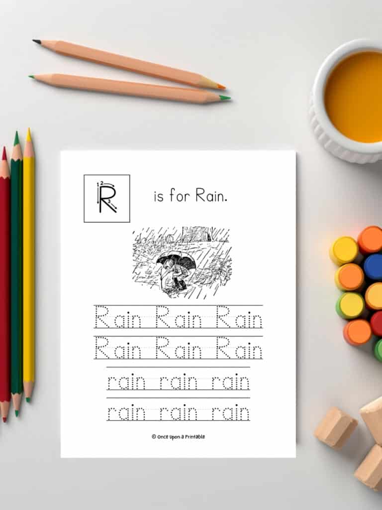 R is for rain letter and word tracing worksheet with illustrations by e. h. shepard laying on a table with coloring supplies.