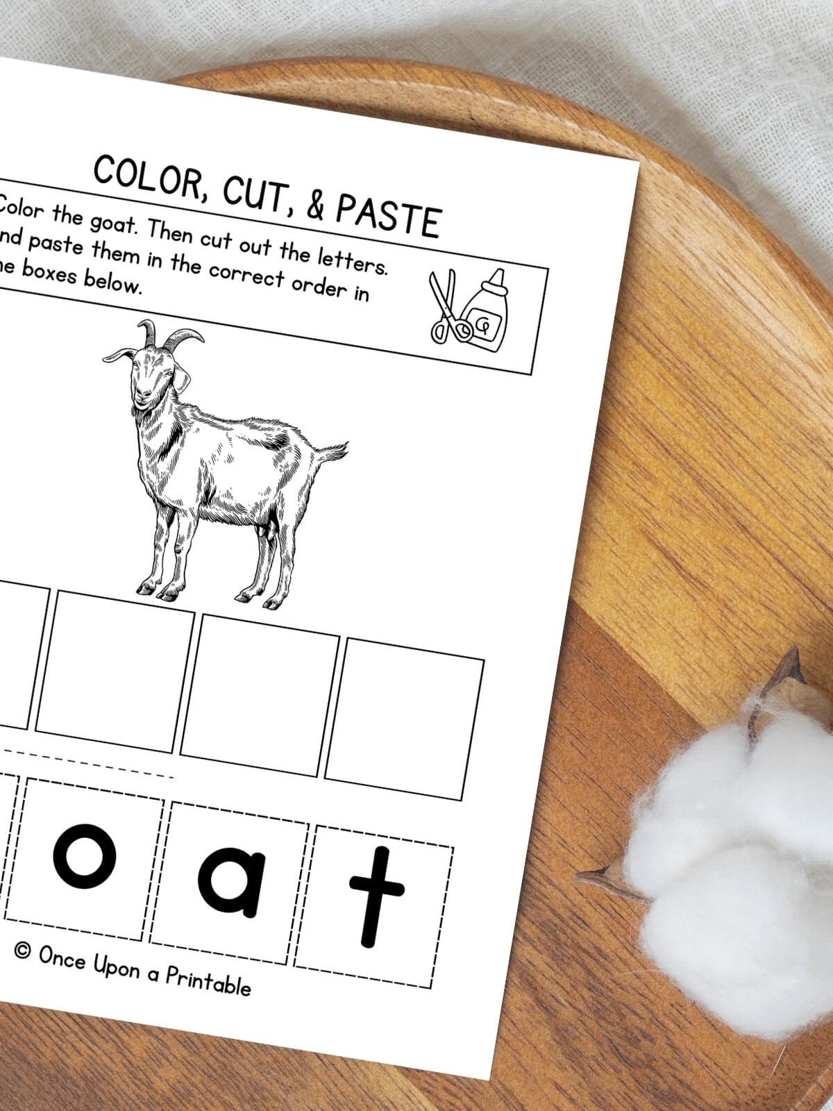 Letter G color, cut, and paste activity pages laying on a wooden lazy Susan.