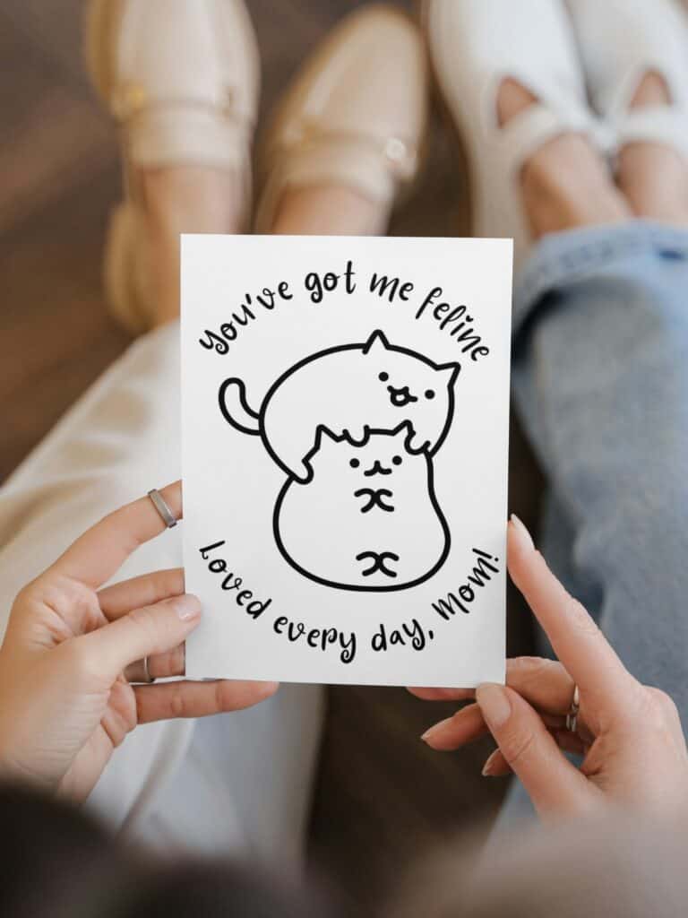 Two cats feline mother's day coloring card being held by a woman. 